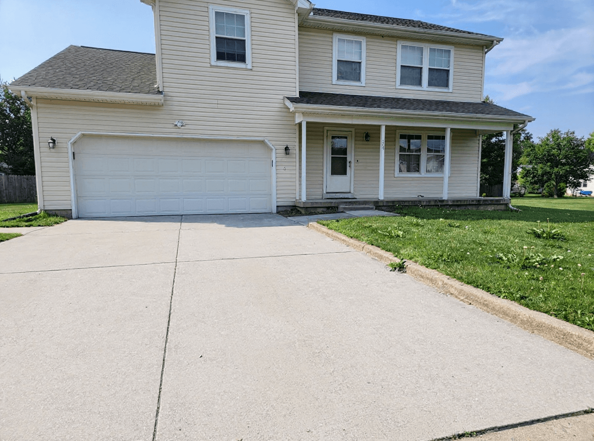 A freshly washed home with clean siding and bright driveway concrete